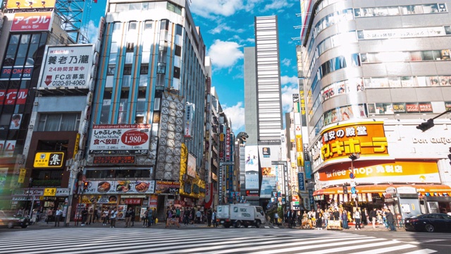 在日本东京新宿区哥斯拉路购物街上行走的行人，4K延时:车流和人群视频素材