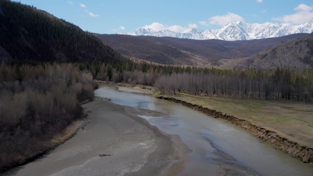 从四轴飞行器上看，群山和雪白的山峰，蓝天为背景。鸟瞰图。视频素材