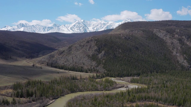 从四轴飞行器上看，群山和雪白的山峰，蓝天为背景。鸟瞰图。视频素材