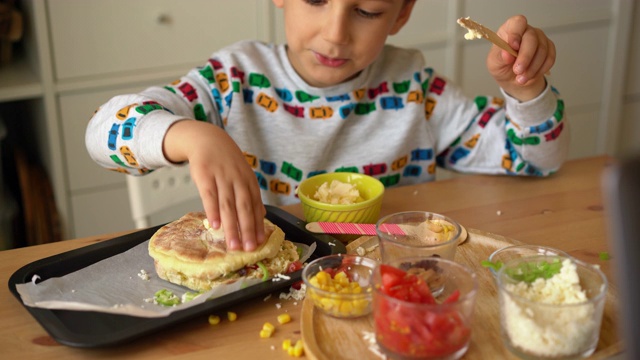 家庭教育-小可爱的男孩做比萨饼和他的母亲在家里-幼儿园活动视频素材