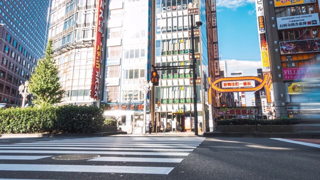 在日本东京新宿歌舞伎町购物街上，行人正走在车流和人群中视频素材