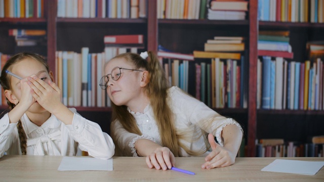 可爱的女学生在学校考试时作弊，把婴儿床放在手上视频素材