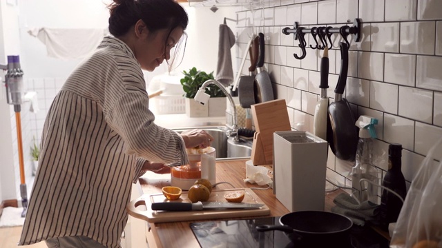 年轻女子在家里准备榨汁。视频素材