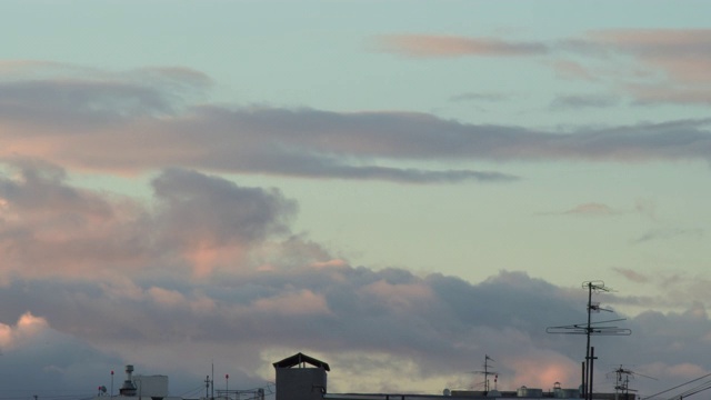 移动的日落云上方的天空在城市的屋顶视频素材