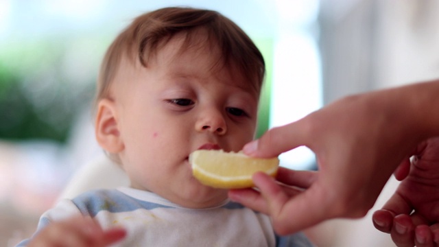 父母给宝宝柠檬。可爱可爱的幼儿脸视频素材