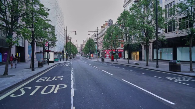 沿着英国伦敦市中心的牛津街(Oxford Street)，黄昏时分人潮稀少，交通繁忙视频素材