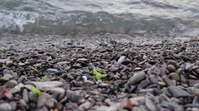 宁静的海浪拍打着夏天的沙滩、岸边的卵石视频素材