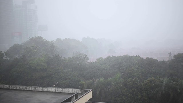 雨天与高角度的视野，停车场屋顶与树木和办公楼的背景视频素材