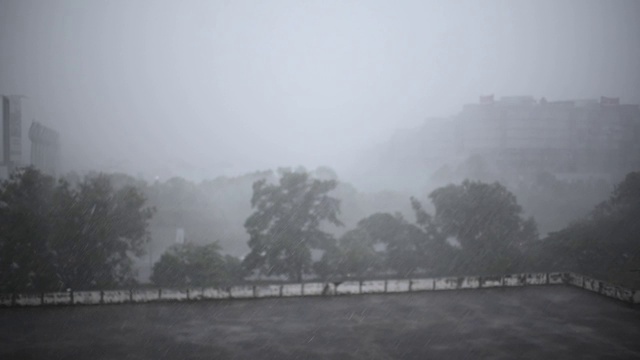 雨天与高角度的视野，停车场屋顶与树木和办公楼的背景视频素材