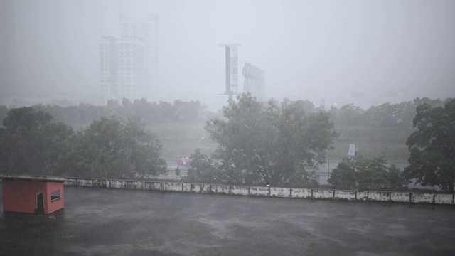 雨天与高角度的视野，停车场屋顶与树木和办公楼的背景视频素材