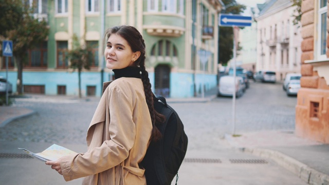 后视图。迷人的年轻女子正在欧洲旅行，探索美丽的风景。她转过身来，微笑着。关闭了。副本的空间。4 k。视频素材