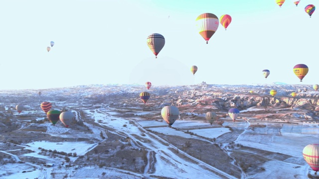 在卡帕多西亚日出时，空中的雪谷景观和大量的热气球视频素材