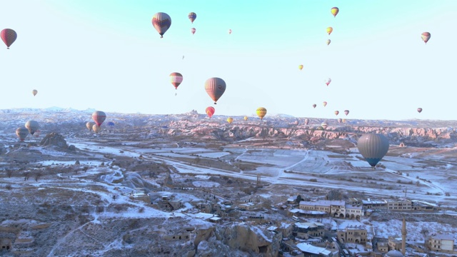 从卡帕多西亚的卡乌辛地区的热气球在日出时的鸟瞰图视频素材