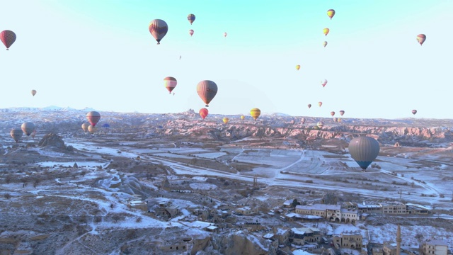 从卡帕多西亚的卡乌辛地区的热气球在日出时的鸟瞰图视频素材