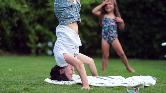 妈妈在户外做瑜伽头倒立。在外面做倒立的女人视频素材