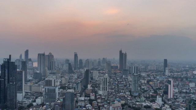 4K白天到夜晚的日落场景在曼谷市中心的现代写字楼和公寓，日落的天空和云彩在曼谷，泰国。视频素材