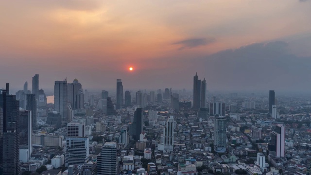 4K白天到夜晚的日落场景在曼谷市中心的现代写字楼和公寓，日落的天空和云彩在曼谷，泰国。视频素材