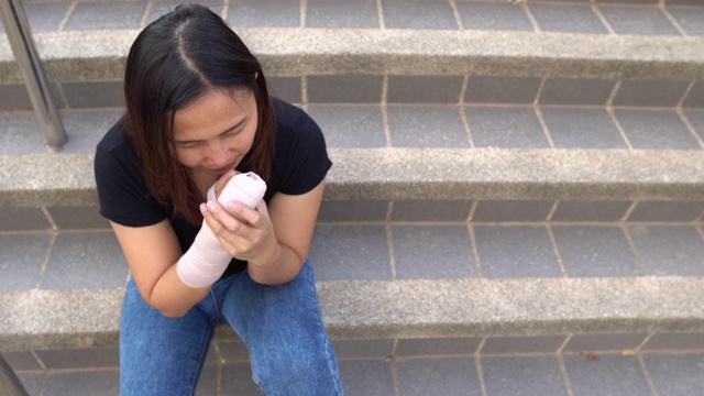 一个漂亮的亚洲女孩摔断了胳膊视频素材