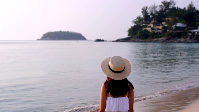 年轻的旅行者女人放松在日落的热带海滩，假期和夏天的概念视频素材