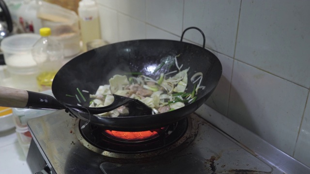 厨师用炒锅炒制日式烧饭的场景特写，蛋肉蔬菜炒鲜面条，食品加工，家常菜，亚洲街头小吃，健康简单的食品，新鲜的配料。视频素材