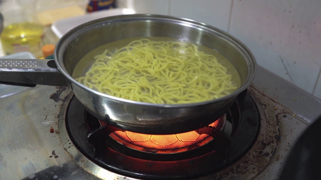 厨师用炒锅炒制日式烧饭的场景特写，蛋肉蔬菜炒鲜面条，食品加工，家常菜，亚洲街头小吃，健康简单的食品，新鲜的配料。视频素材