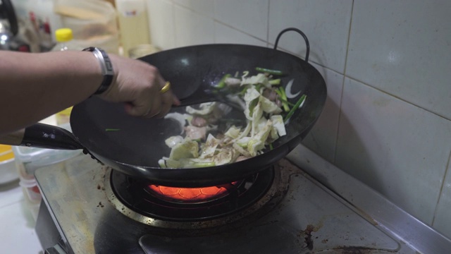 厨师用炒锅炒制日式烧饭的场景特写，蛋肉蔬菜炒鲜面条，食品加工，家常菜，亚洲街头小吃，健康简单的食品，新鲜的配料。视频素材