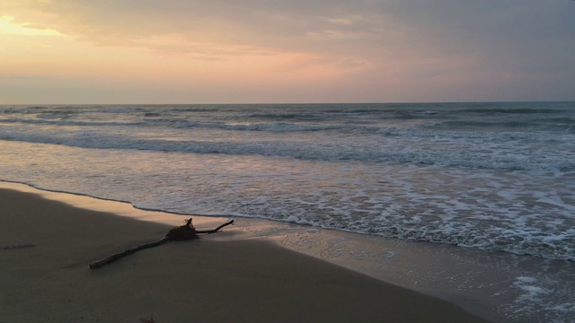 孤独的海滩，低低的海浪上柔和的夕阳视频下载