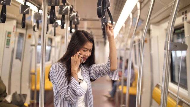 在地铁里打电话的亚洲女人视频素材