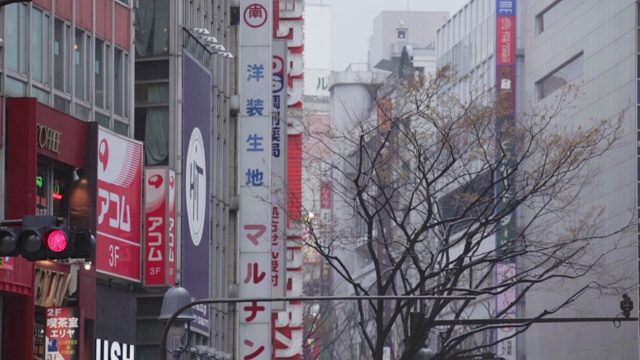 涉谷十字路口的人们打着雨伞，以城市为背景视频素材