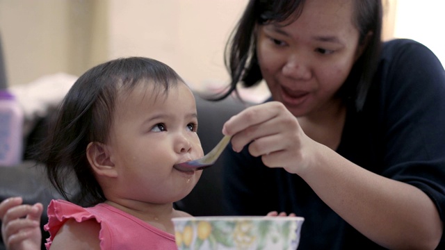 一个亚洲女婴被她的母亲喂食的特写视频素材