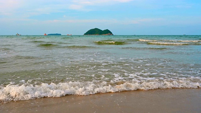 热带海滩的海浪打破热带白色沙滩的观点。海浪在美丽的沙滩上无缝循环。视频素材