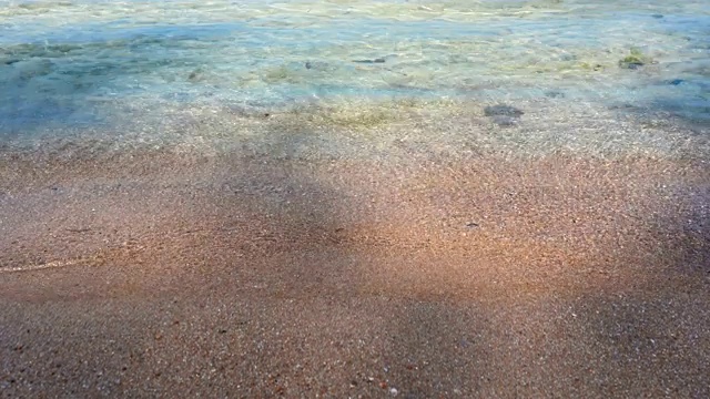 热带海滩的海浪打破热带白色沙滩的观点。海浪在美丽的沙滩上无缝循环。视频素材