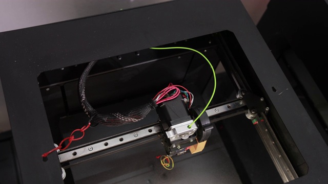 3D技术两名男子的手将塑料灰色线推入打印机的尖头视频素材