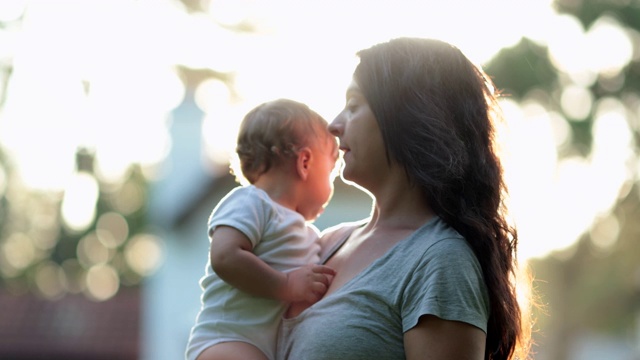 日落时分，妈妈抱着婴儿抓挠鼻子和脸部过敏视频素材