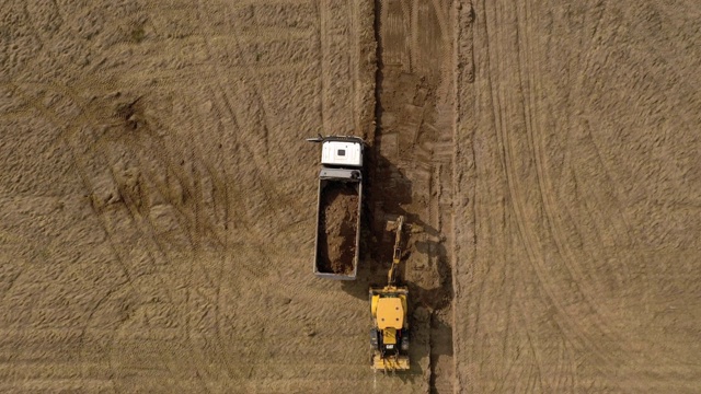 装载机挖掘机在道路建设中在卡车上装载地面视频素材