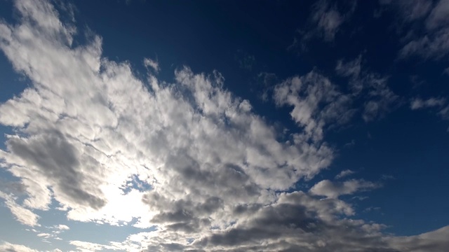 时间流逝:阳光穿过蓬松的云在天空中飞行。晴朗的白天。4 k视频素材