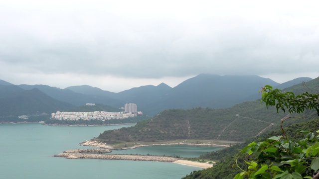 多云的景观海阴影在绿松石水岩石岸山草视频素材