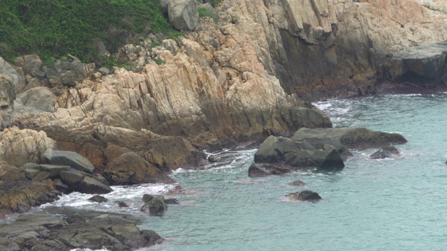 缓慢的海浪在岩石悬崖海岸浅蓝色的水视频素材