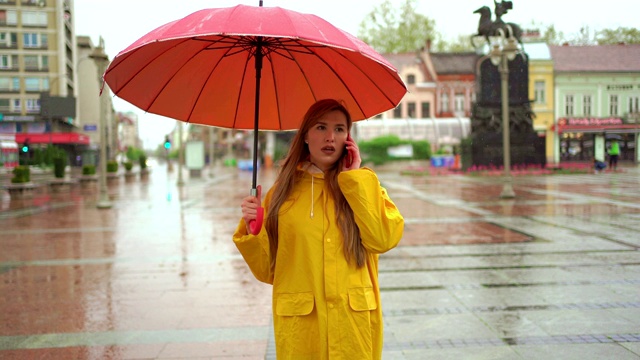 一个年轻女子在雨天打电话视频素材