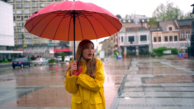 女人在雨天和寒冷的日子里在城市里。视频素材