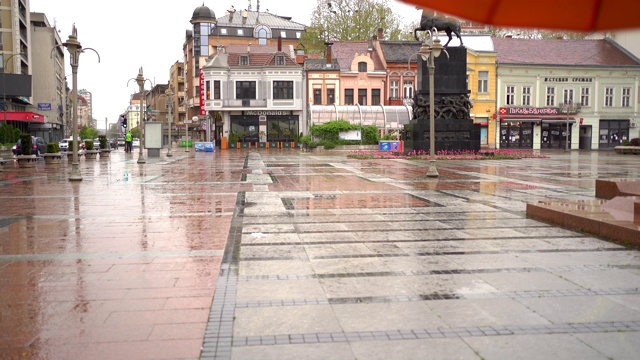 一个年轻女子在雨天走在城市里视频素材