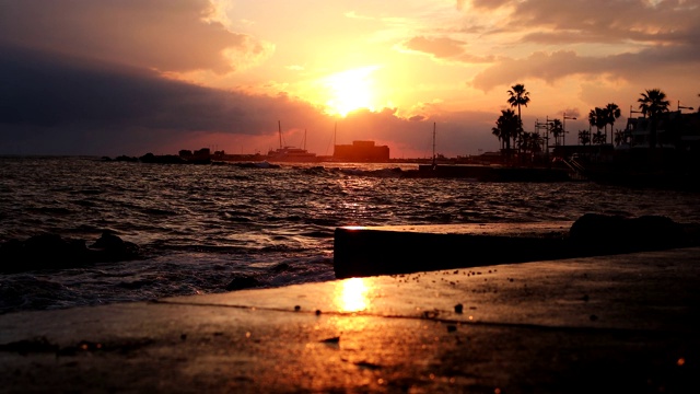 海滩上令人惊叹的日出。海面上的黄色太阳。橙色波。自然背景。美丽宁静的场景。早....阳光反射在水面上。日落俯瞰大海、城市、船只视频素材