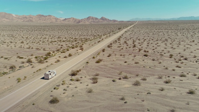 无人机拍摄到一辆房车在荒无人烟的空旷道路上行驶视频素材