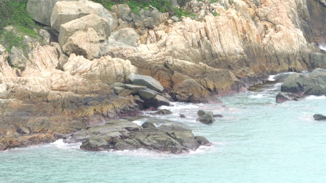 海浪在岩石海岸悬崖青绿色的蓝色苍白的海视频素材