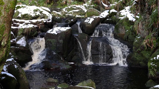 威克洛县的一条河，滚过巨石和积雪，掉进一个池塘视频素材