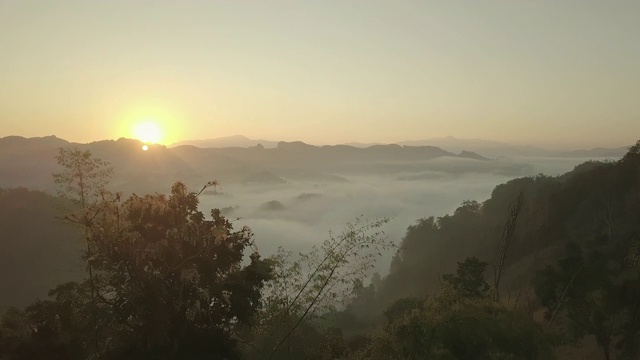 鸟瞰图的雾滚过流动在泰国北部的雨林山视频素材