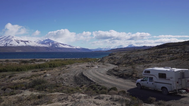 一辆小型露营车正行驶在通往山区湖泊的路上视频素材