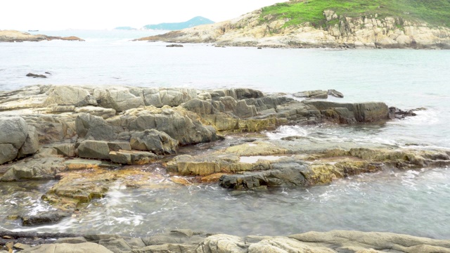 岩石海岸水晶清澈的水冲刷海岸视频素材