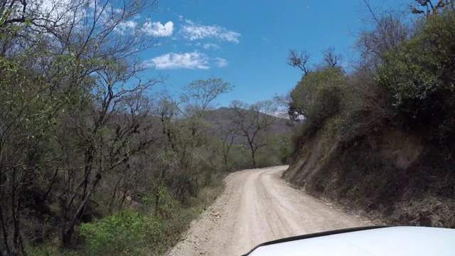 一辆POV车在山中的一条土路上行驶视频素材