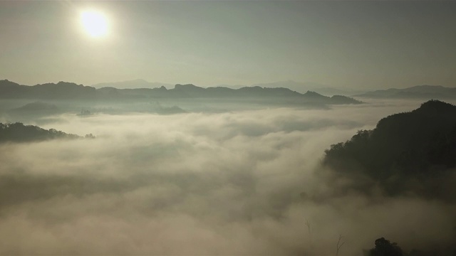 鸟瞰图的雾滚过流动在泰国北部的雨林山视频素材